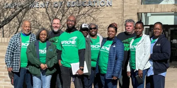 Photo of members of AFSCME Local 1899 in green shirts standing together in a group