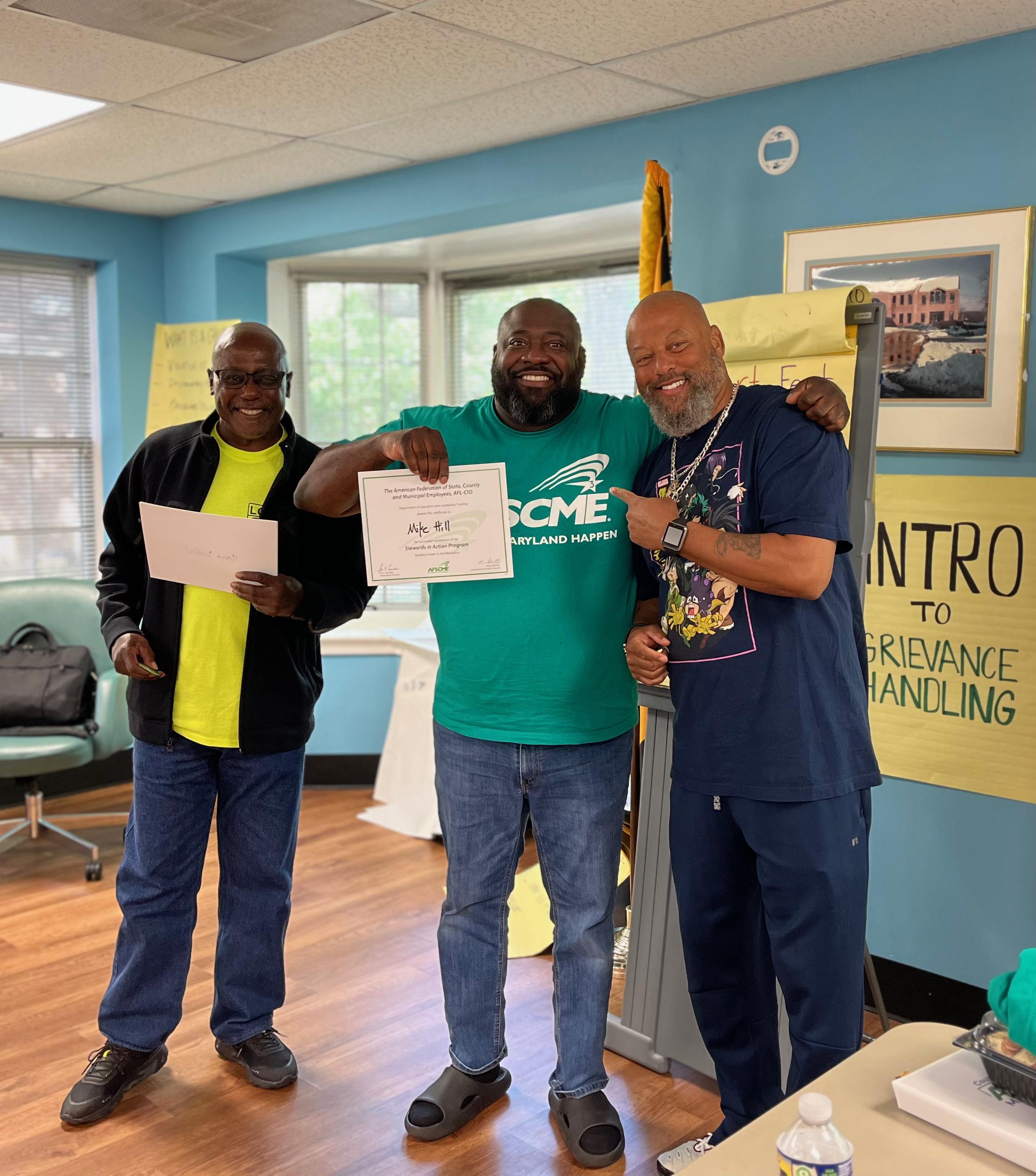 AFSCME Local 2898 Member Mike Hill standing with Local 631 member Kenny Nugent and Local President Wynton Johnson